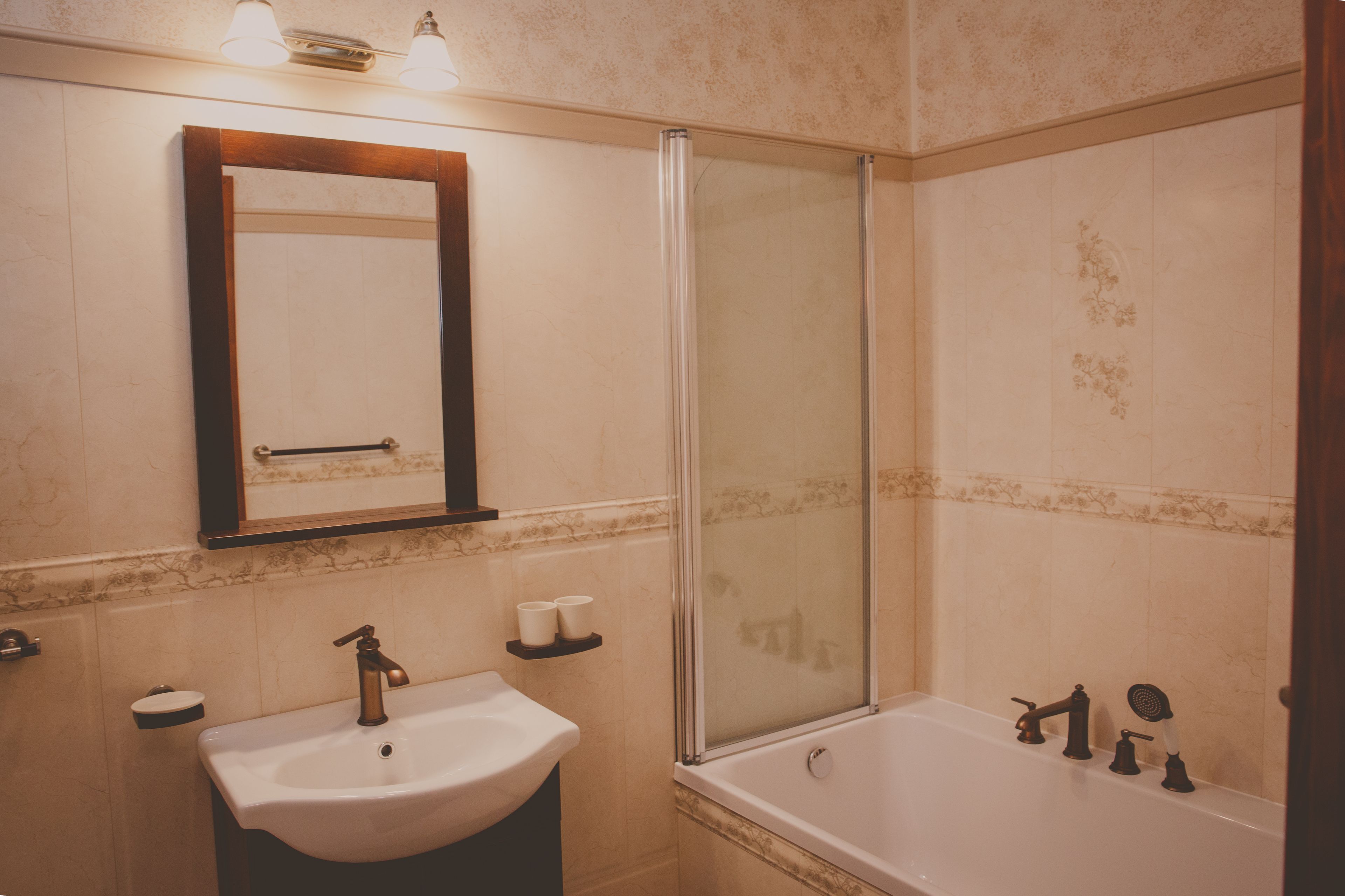 Un baño con lavamanos, espejo y bañera.