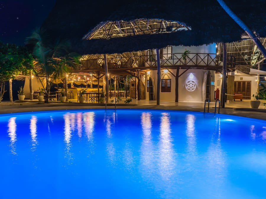 Een buitenzwembad, ligstoelen bij het zwembad