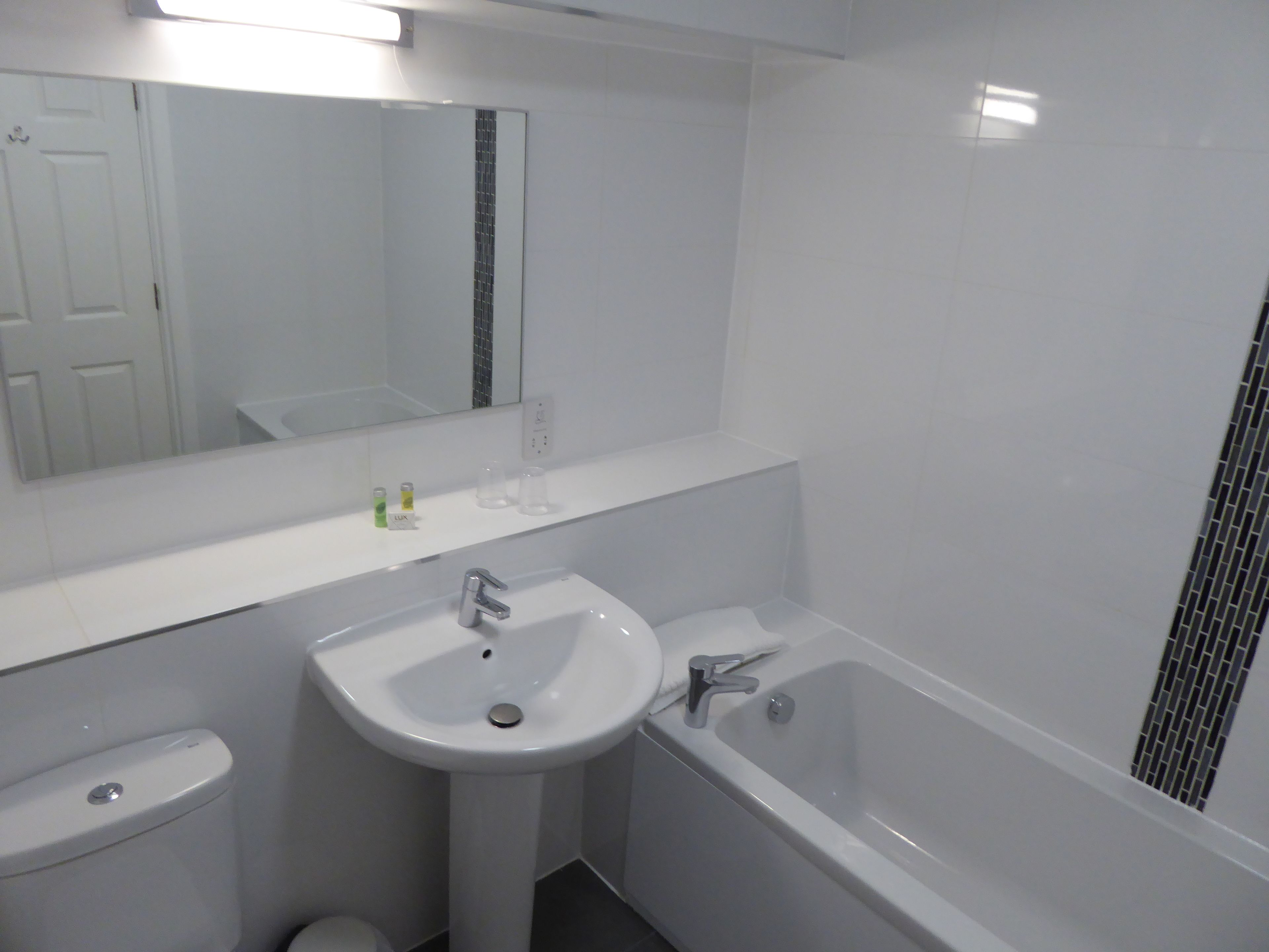 A bathroom with a white sink, a toilet, and a bathtub.