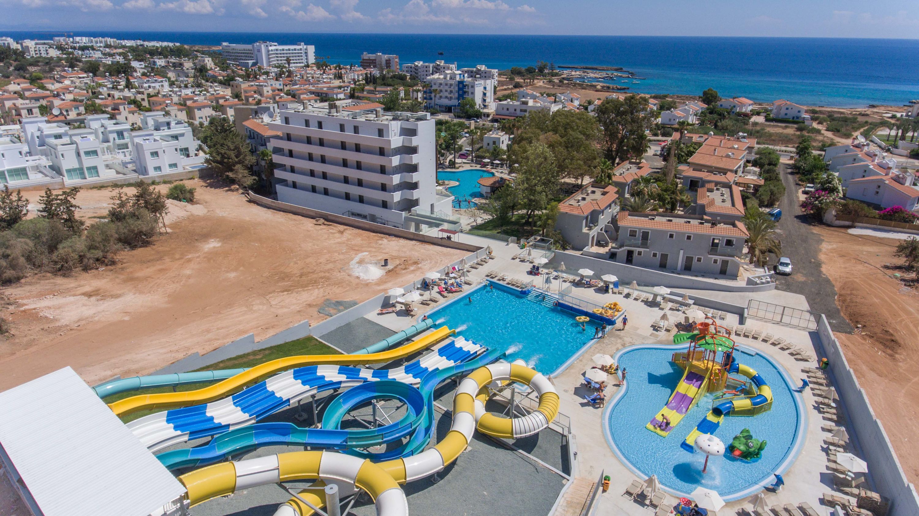 A resort with multiple swimming pools, including a water park area with slides and a separate pool with a slide.