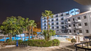 A hotel with a pool, outdoor seating, and a modern building with balconies. - Narcissos Waterpark Resort (Paralimni)