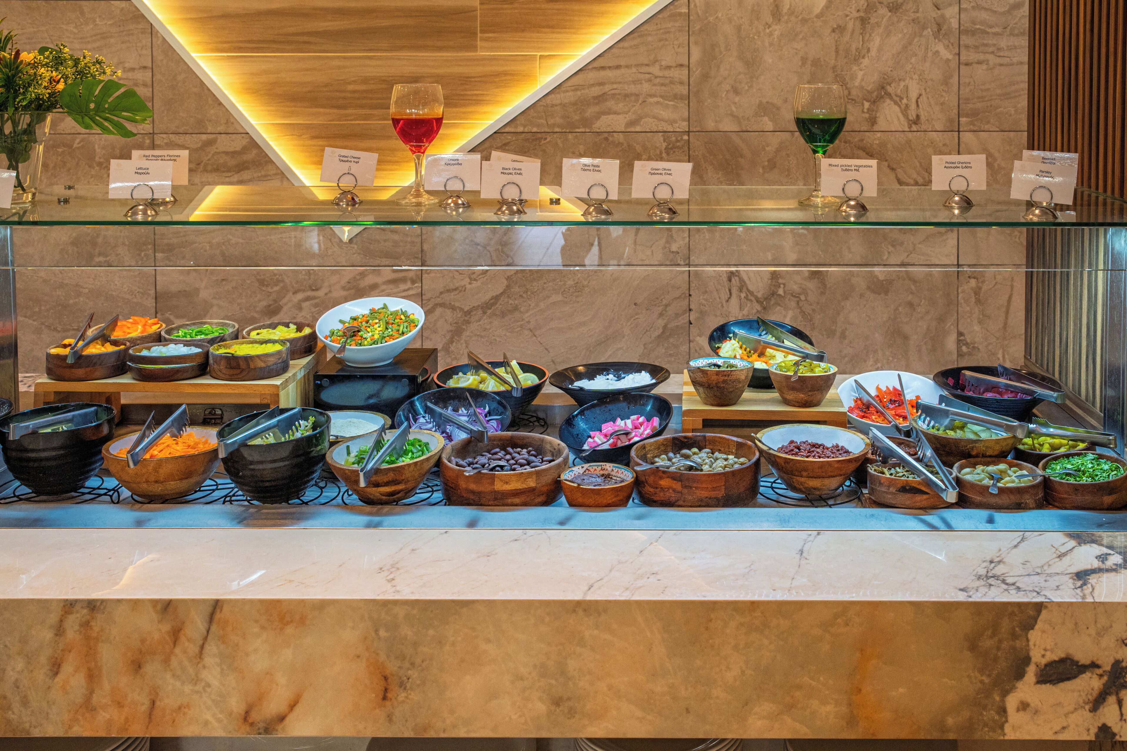 A buffet with various food items and wine glasses.