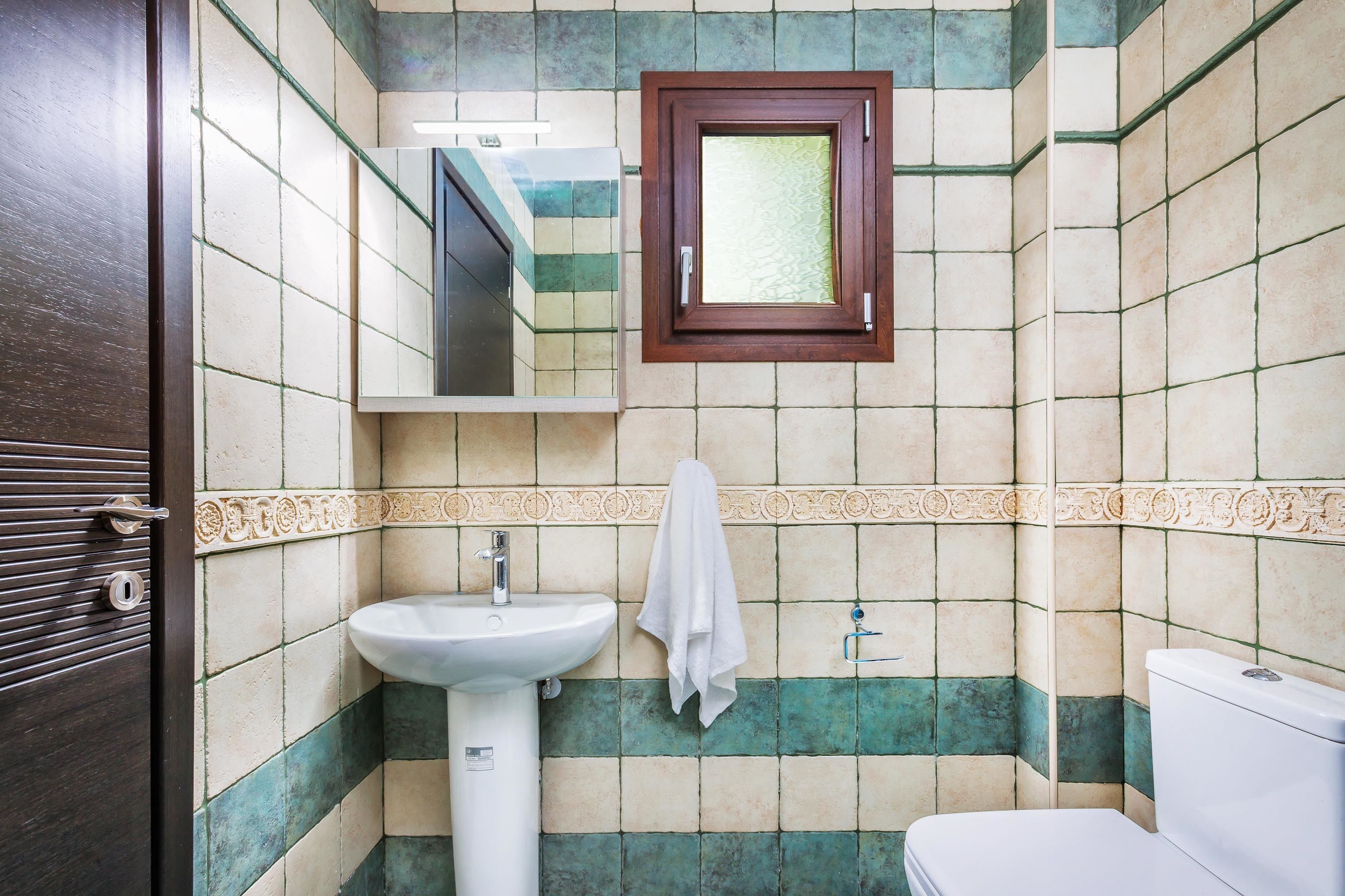 Une salle de bain avec un lavabo, des toilettes et un miroir au-dessus du lavabo.