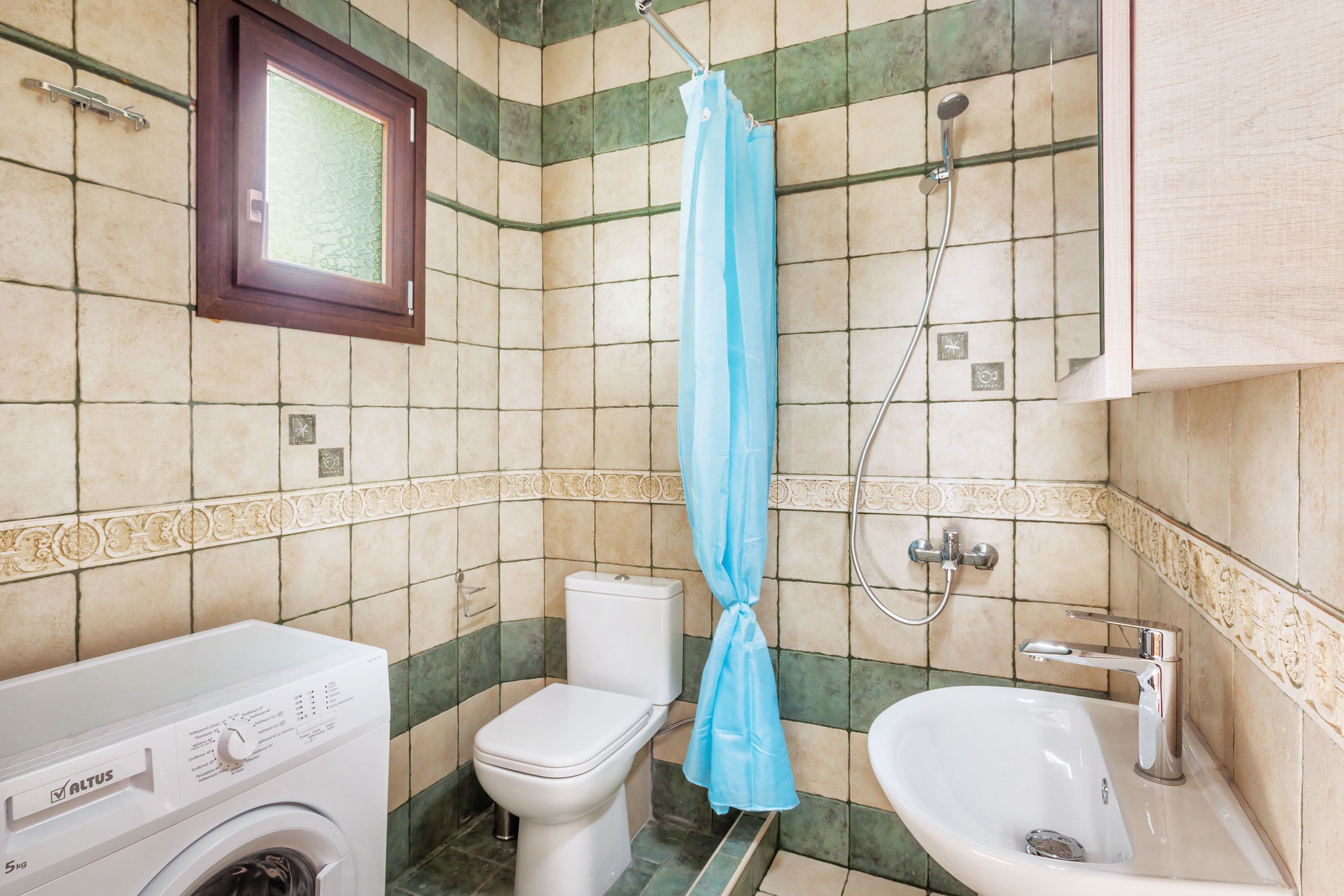 Ein Badezimmer mit Waschmaschine, Toilette und Waschbecken.