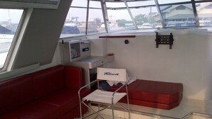 A compact cabin with a red couch, a small table, and a bench. - Laislabonita (Labuan Bajo)