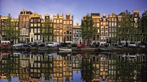 Ein Kanal mit Spiegelungen von Gebäuden im Wasser, mit einer Reihe traditioneller europäischer Architektur.