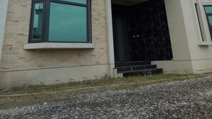Un edificio moderno con fachada plana, ventanas amplias y entrada cubierta.