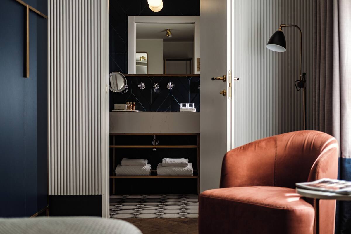 Un bagno moderno con uno specchio grande, un lavandino e un porta asciugamani.