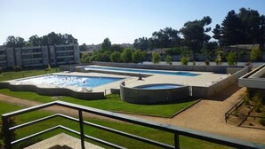 A swimming pool area with multiple pools and a grassy deck. - Depto Algarrobo Condominio Regata 1032 (Algarrobo)