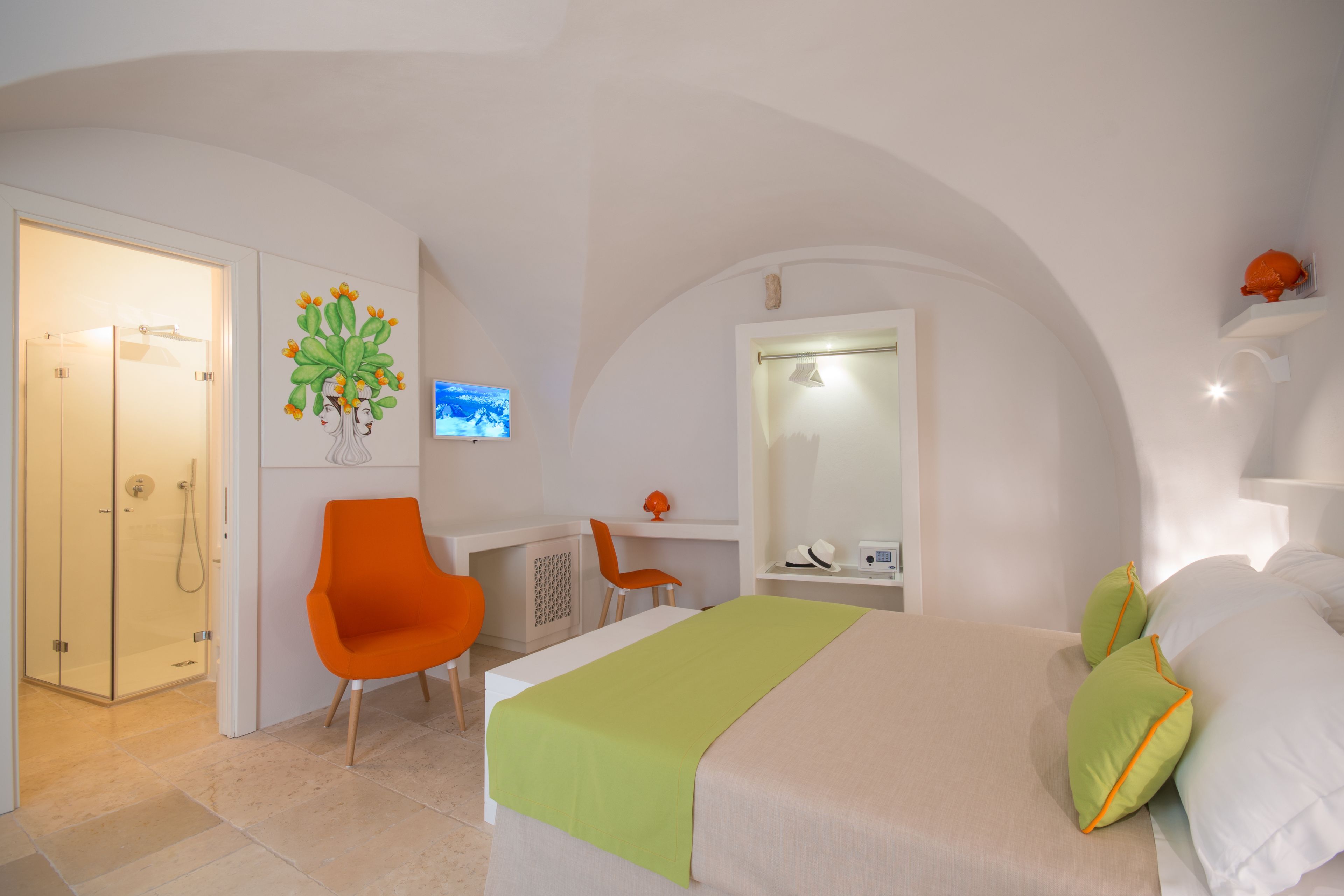 Ein Hotelzimmer mit Bett, Schreibtisch, Stuhl und Duschbereich.