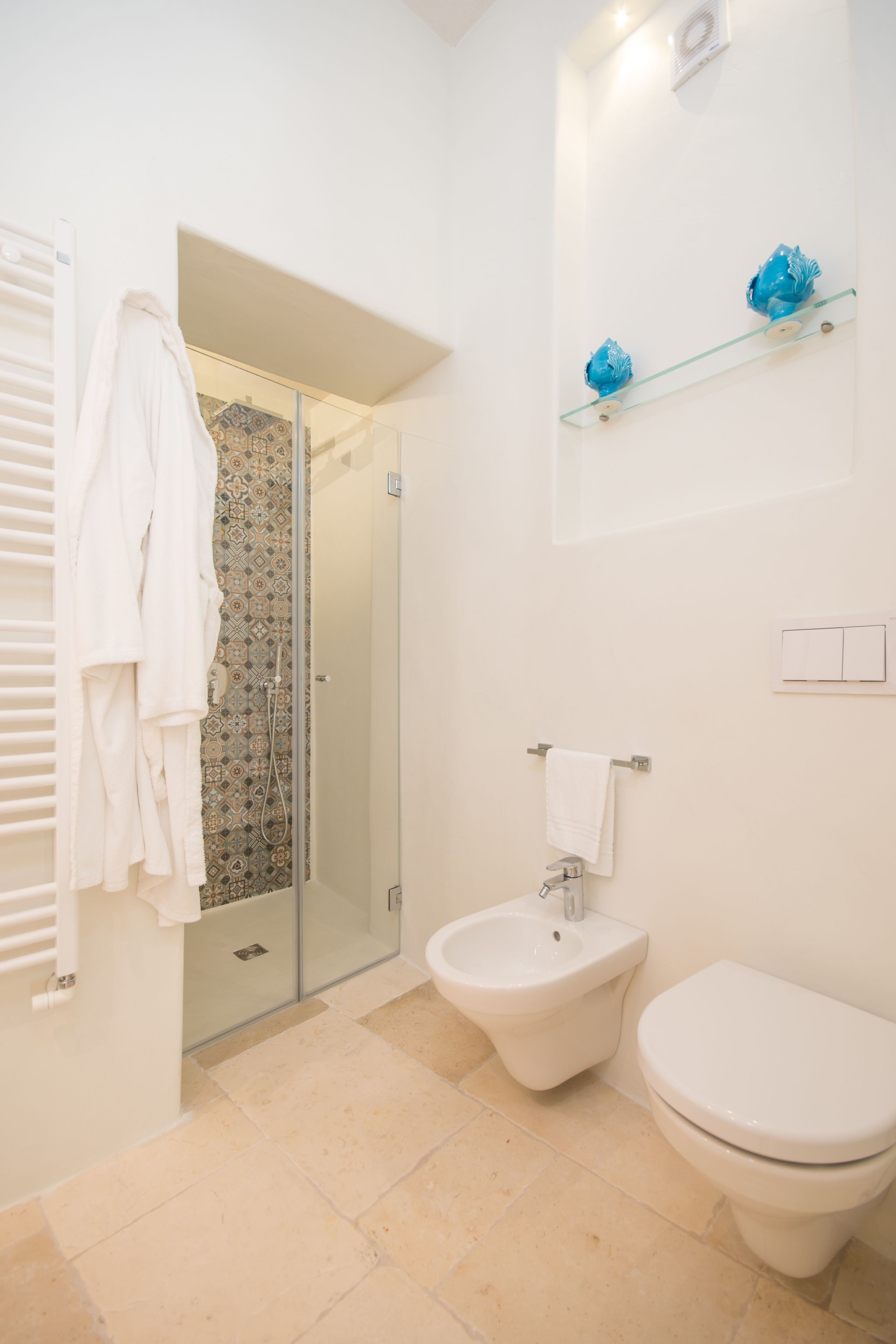 Ein modernes Badezimmer mit Duschkabine aus Glas, einem Bidet und einer Toilette.