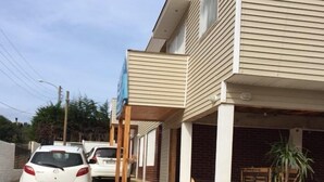 A residential street with houses, a paved driveway, and parked cars. - Cabaña en Algarrobo 1 El Canelo (Algarrobo)