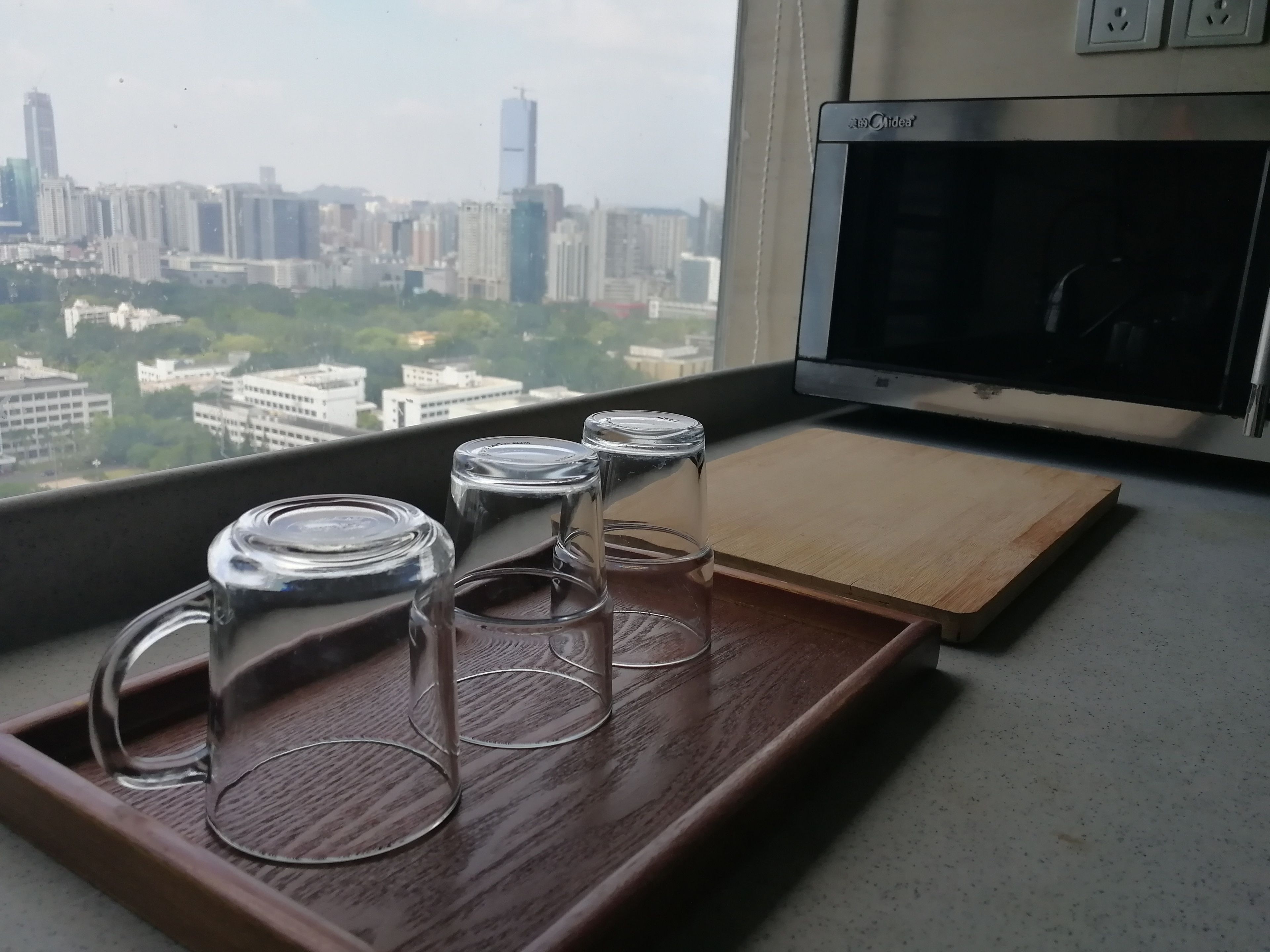 A window view of a cityscape with buildings and a clear sky.
