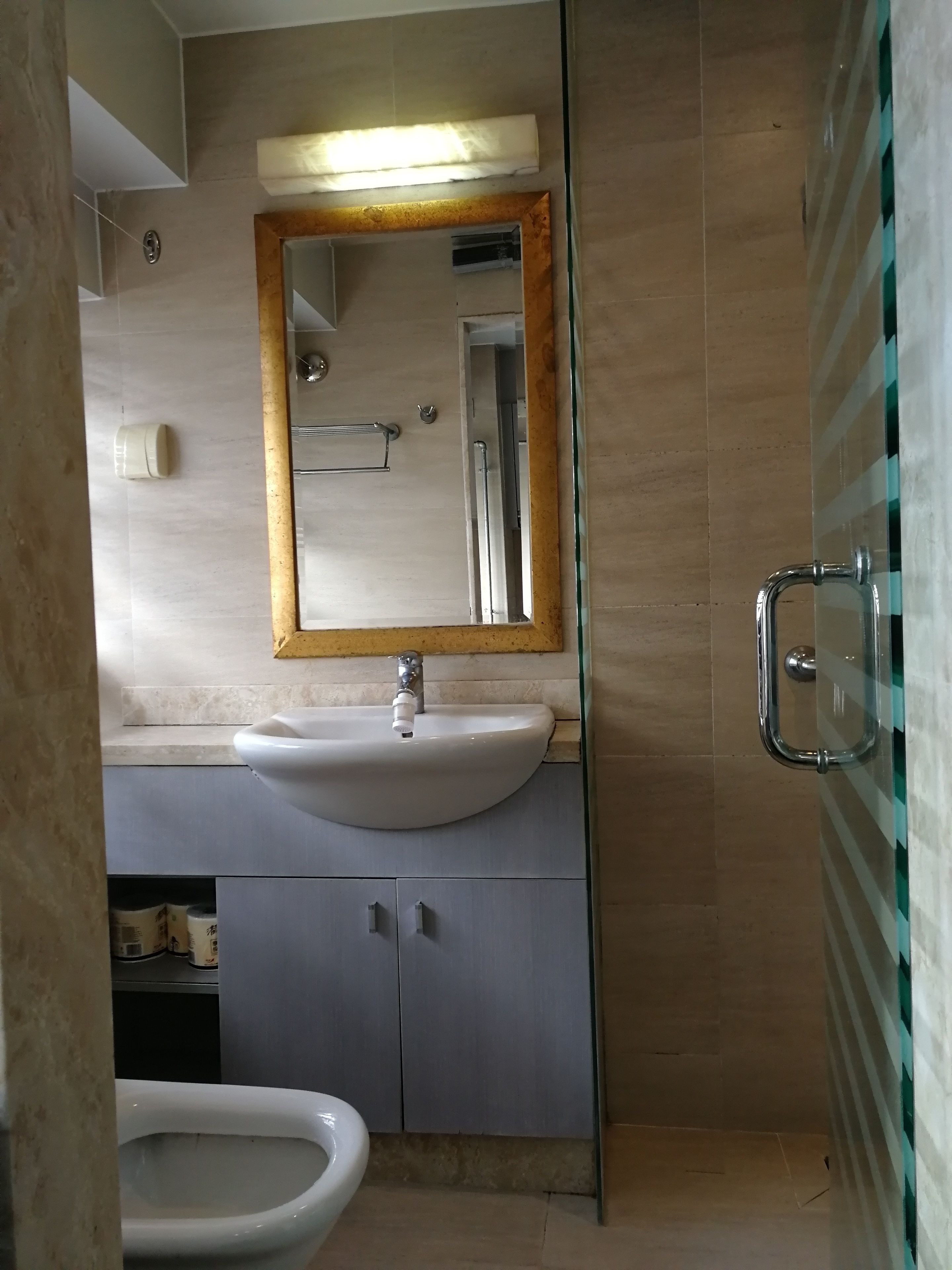 A bathroom with a sink, mirror, and toilet.