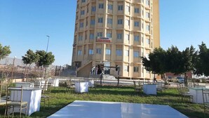 Um hotel com vários andares e uma escadaria central que leva à entrada.