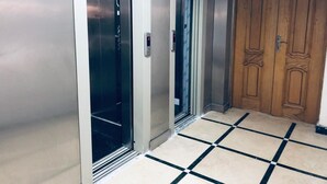Um elevador com interior metálico e porta de madeira.