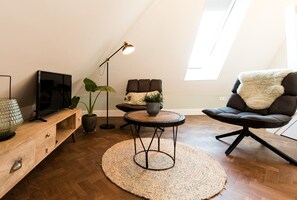 Loft Deluxe, 1 cama King size | Área de sala de estar | Televisión de pantalla plana