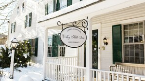 En vit byggnad med en skylt som visar texten ”Colby Hill Inn” och ”Entré för gäster”.