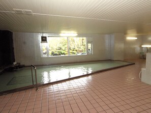 A swimming pool with a view of greenery outside.