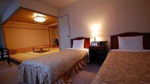 A hotel room with two beds, a sitting area with a low table, and a television. - Panoramaland Kijimadaira (Kijimadaira)