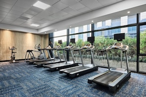 A gym with treadmills, stationary bikes, and a rowing machine.