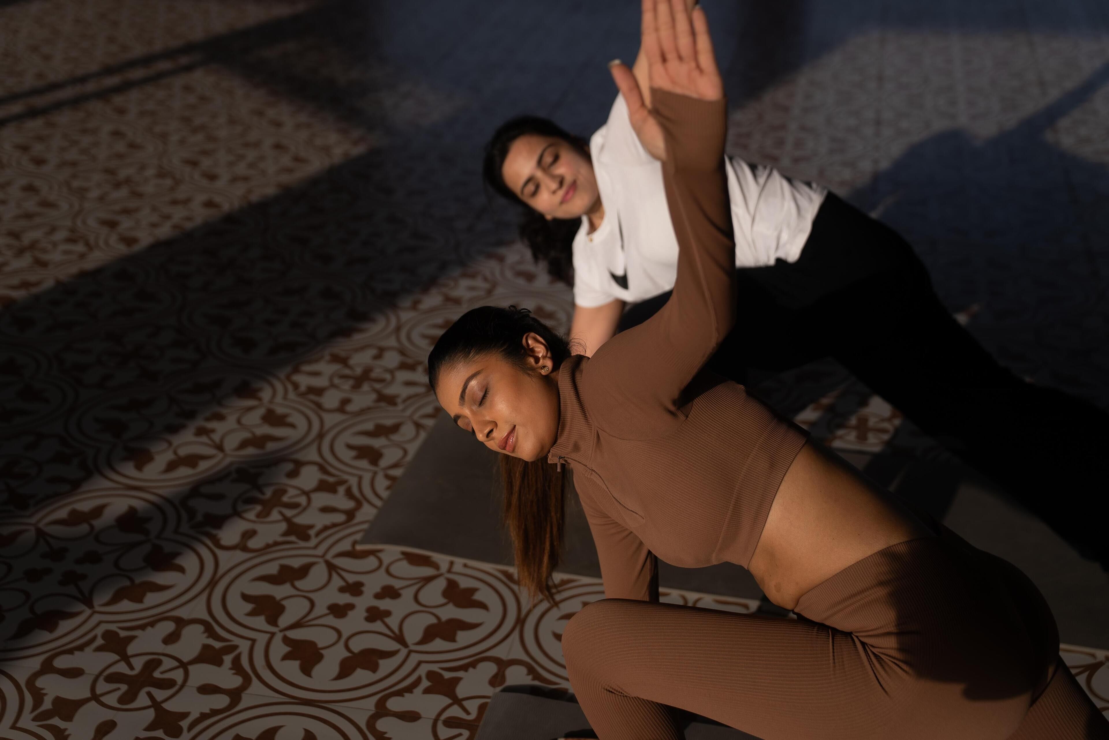 Two people in a room with patterned flooring and a patterned wall.