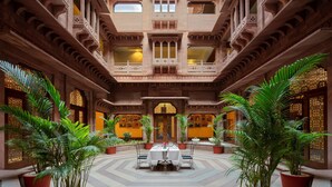 A spacious courtyard with a central dining area, surrounded by ornate balconies and potted plants. - Radisson Hotel Jodhpur (Jodhpur)