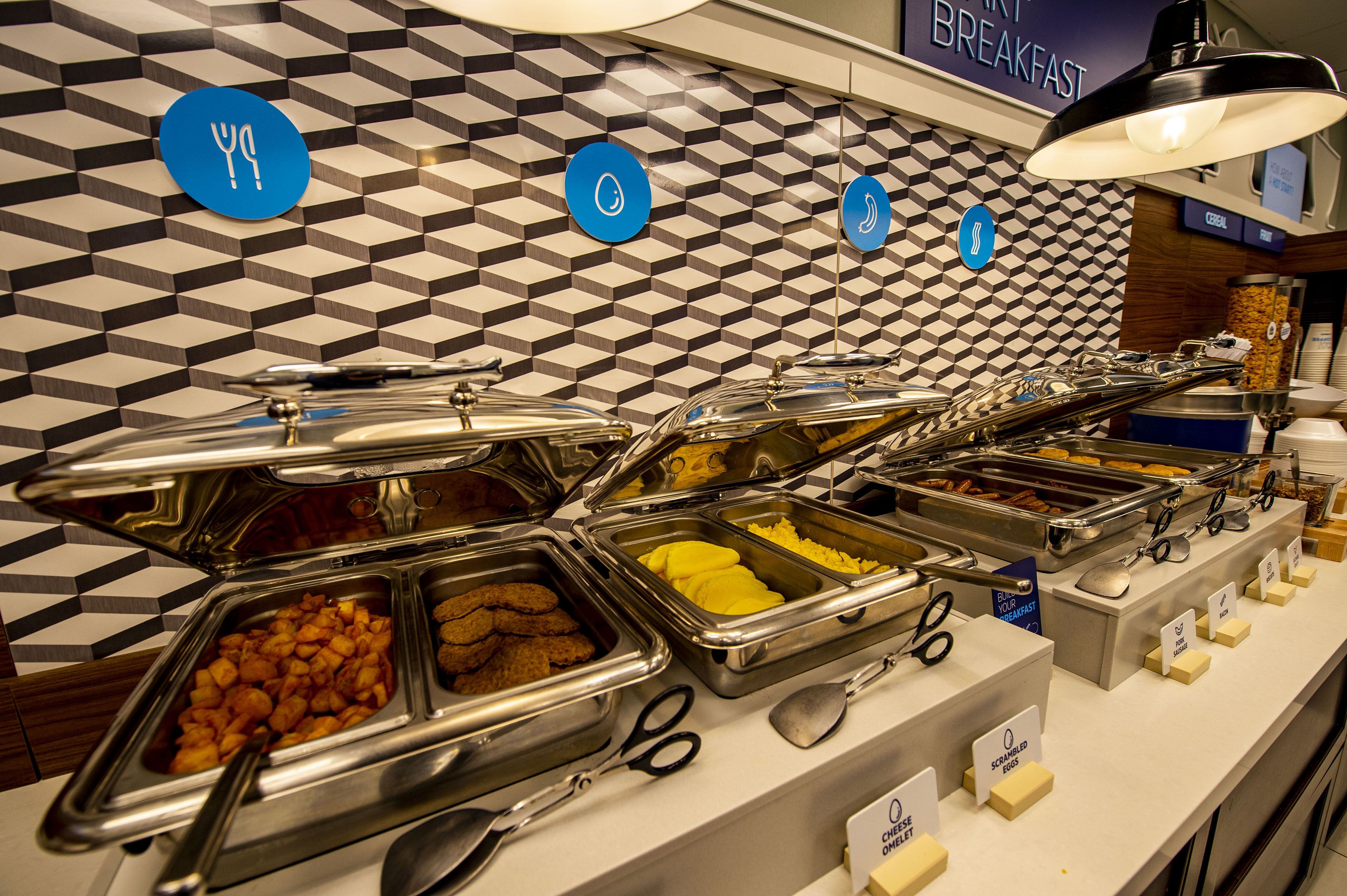 Un bufé con diversas opciones de comida y utensilios.