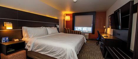 A hotel room with a bed, bedside table, lamp, TV, and a window with a view.