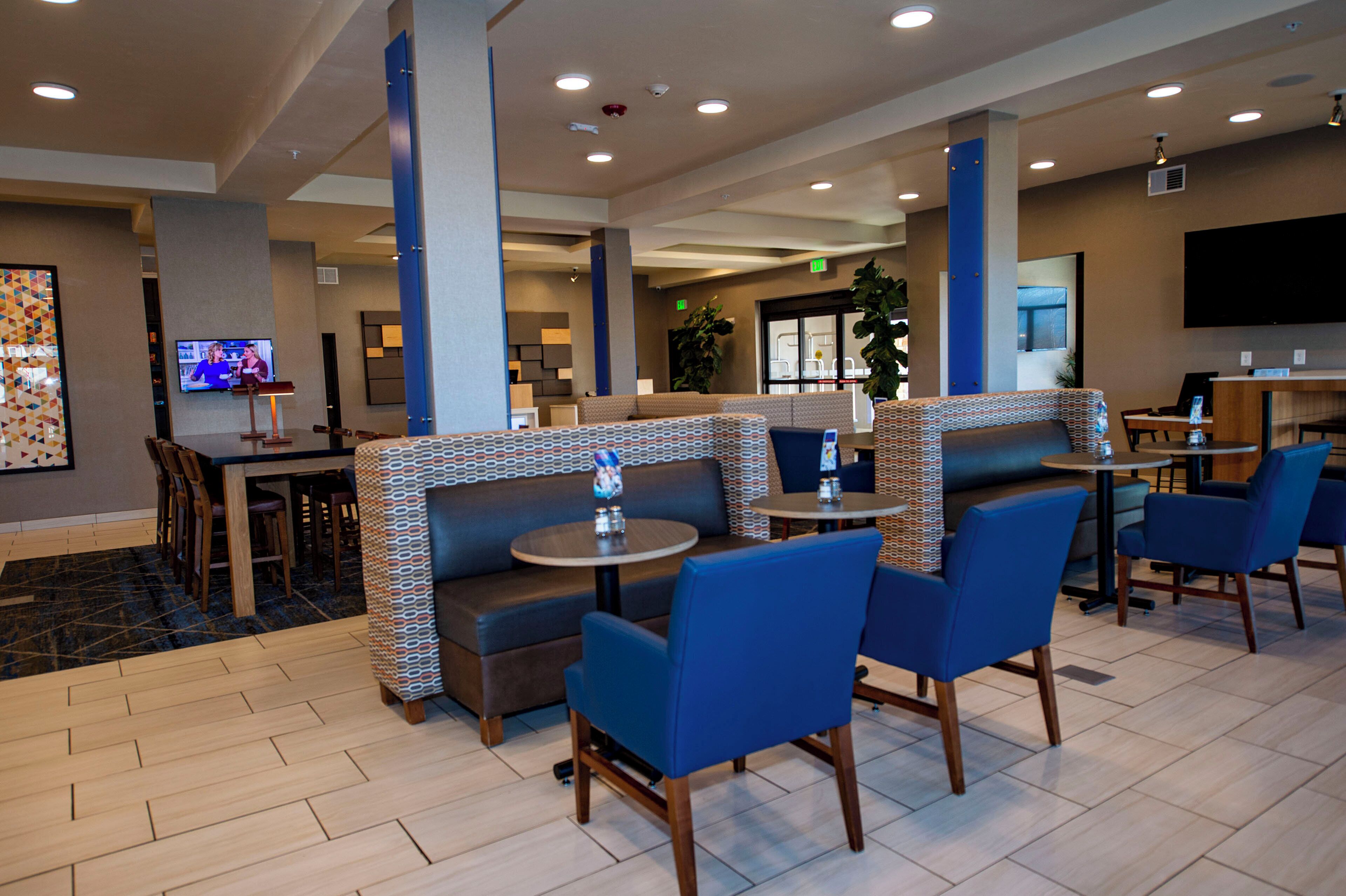 A hotel lobby with seating areas, a television, and a reception desk.