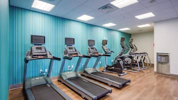 A fitness center with treadmills, ellipticals, and a water dispenser.