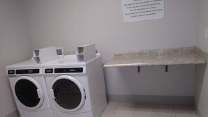 Une buanderie équipée de deux machines à laver à chargement frontal et d’un plan de travail.