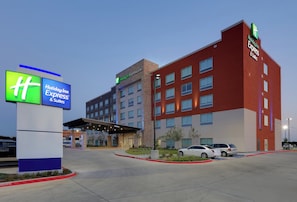A Holiday Inn Express & Suites hotel with a modern design, featuring a prominent entrance and a parking area. - Holiday Inn Express & Suites Dallas NW HWY - Love Field by IHG (Dallas)