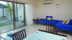 A room with a glass door leading to a patio, a bed with blue bedding, a ceiling fan, and an air conditioning unit. - Apartamento PlayaDelCarmen 489 by Sinbad (Playa del Carmen)