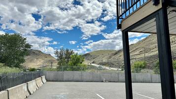An outdoor parking area with a clear view of a mountainous landscape under a partly cloudy sky.