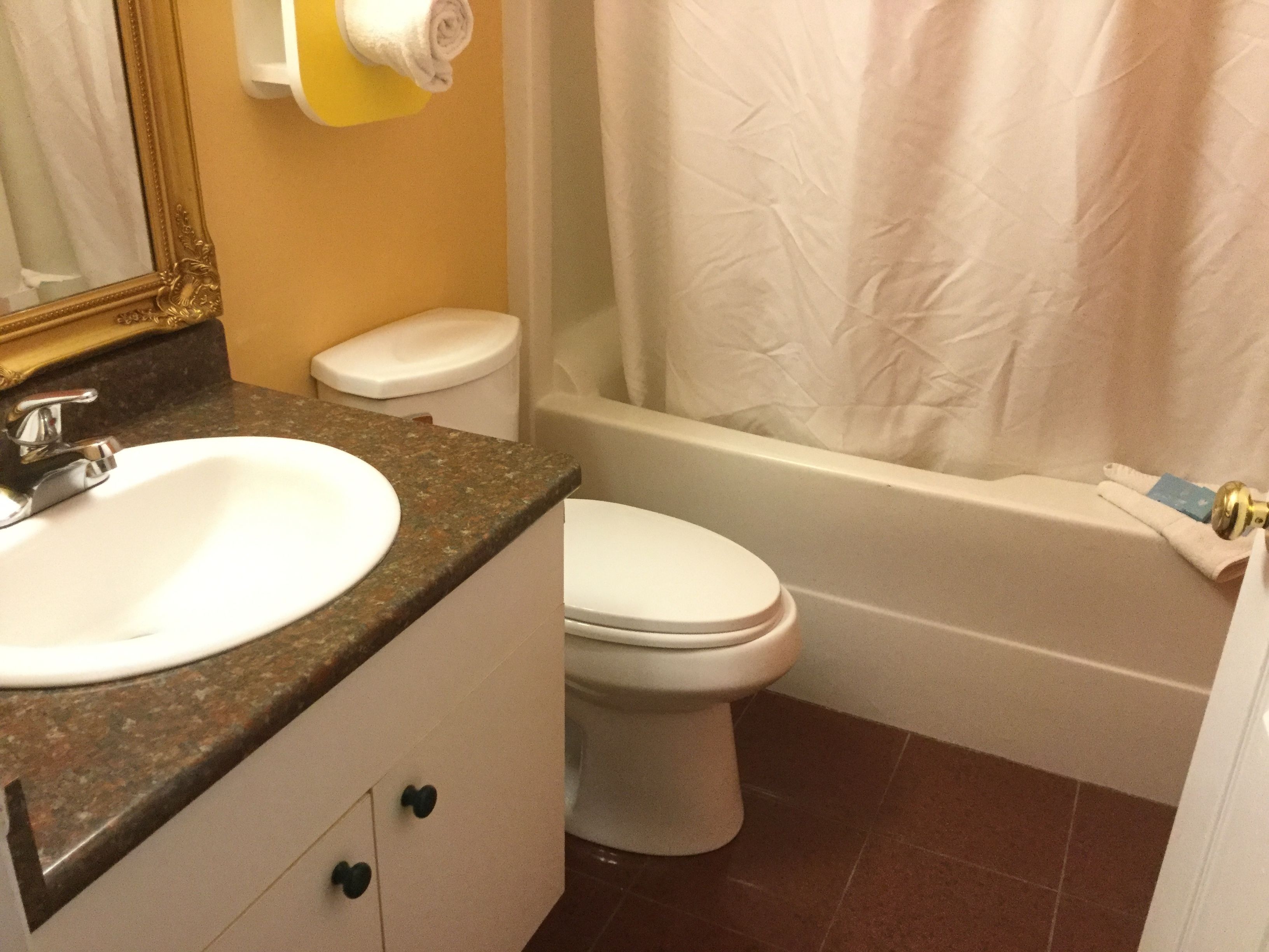 A bathroom with a sink, toilet, and bathtub.