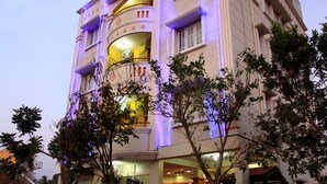 A multi-story hotel with a curved facade, balconies, and a reception area. - Hoppers Stop Yelahanka (Bengaluru)