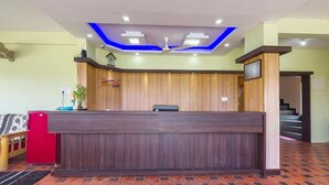 A reception desk with a wooden finish, a ceiling fan, and a clock on the wall. - Hoppers Stop Yelahanka (Bengaluru)
