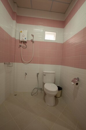A bathroom with a toilet, a shower, and a small window. - Chiang Kham Grand Villa (Chiang Kham)