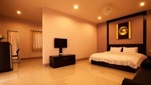 A hotel room with a large bed, a bedside table, a flat-screen TV, and a wall-mounted artwork. - Chiang Kham Grand Villa (Chiang Kham)