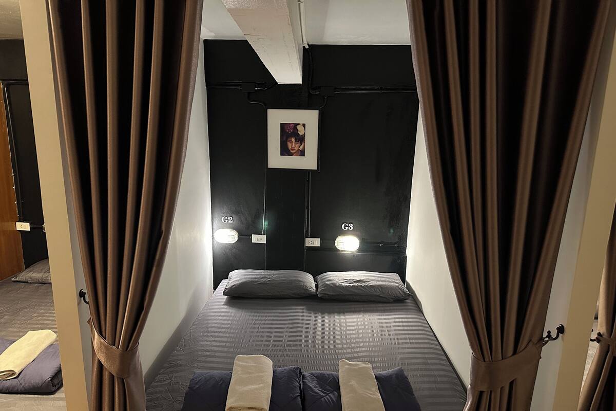 A room with a bed, curtains, and two bedside lamps labeled G2 and G3.