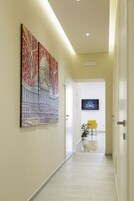 Een hal met een modern design, met een aan de muur bevestigd kunstwerk en een bordje met de tekst 'The Five Rooms'.
