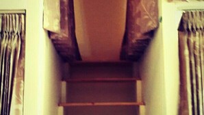 A staircase with a handrail and patterned curtains on either side. - Smile Capsule Hostel (Chiang Mai)