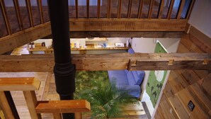 A wooden staircase with a view of a room below, including a blue sofa and a small table with items on it. - Gufo no Mori Kamifurano (Kamifurano)