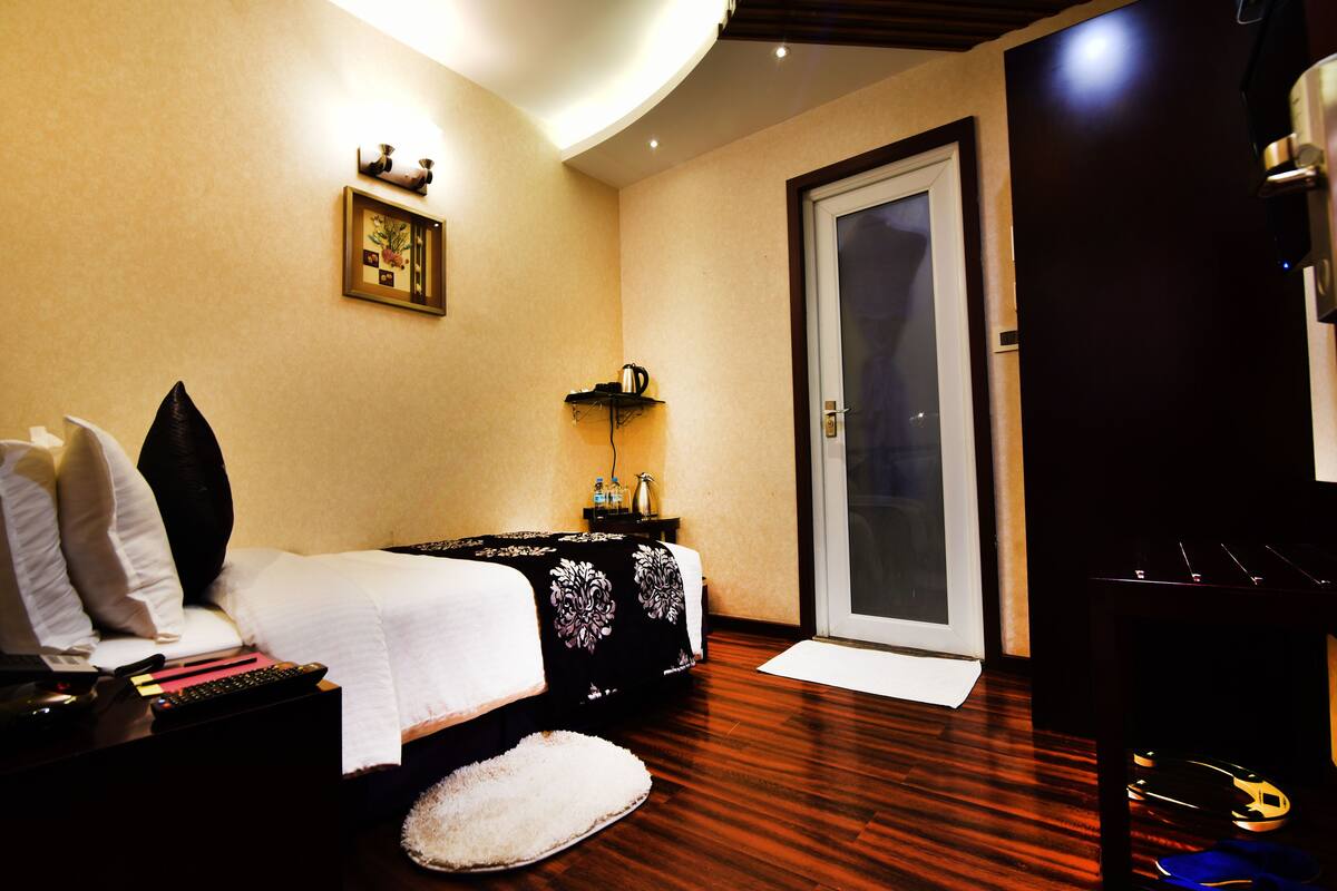 Ein Hotelzimmer mit Bett, Nachttisch und einer Tür zum Balkon.