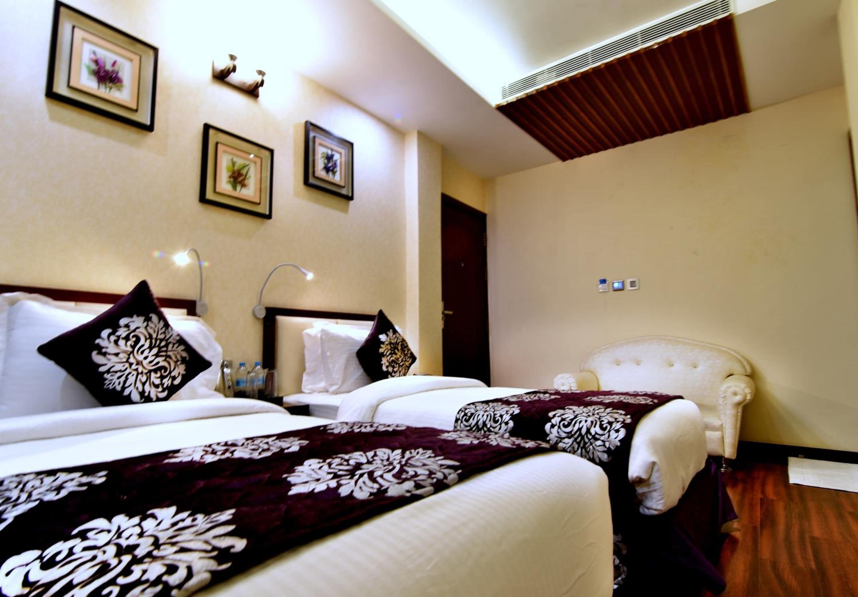 A hotel room with two beds, a large window, and a wooden ceiling.