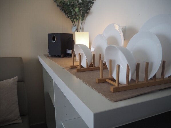 A white desk with a speaker and a vase of green plants. - May's Place @ Evo Soho Suites (Bandar Baru Bangi)