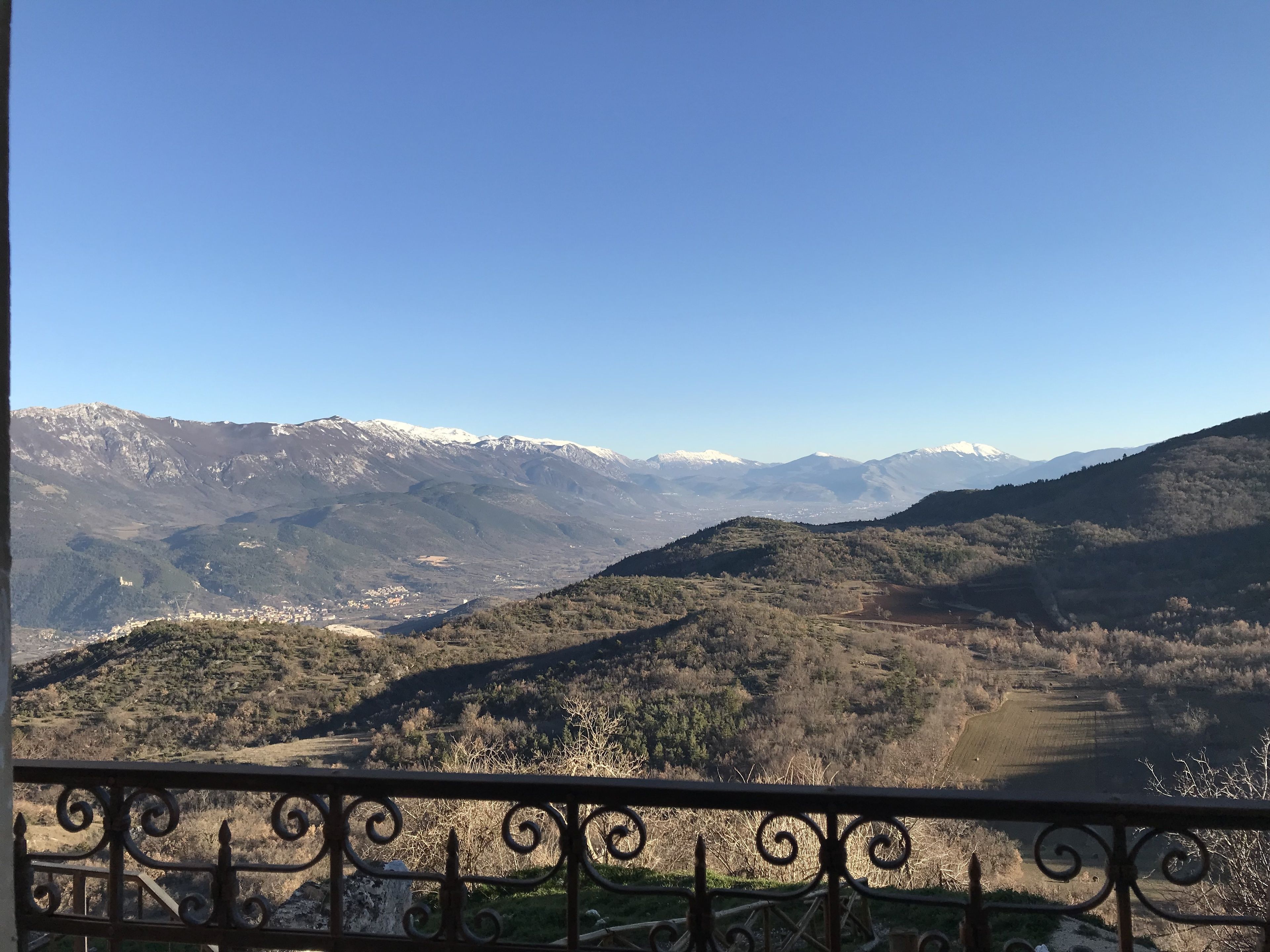 Un paysage montagneux, avec des sommets enneigés et une vallée en contrebas.