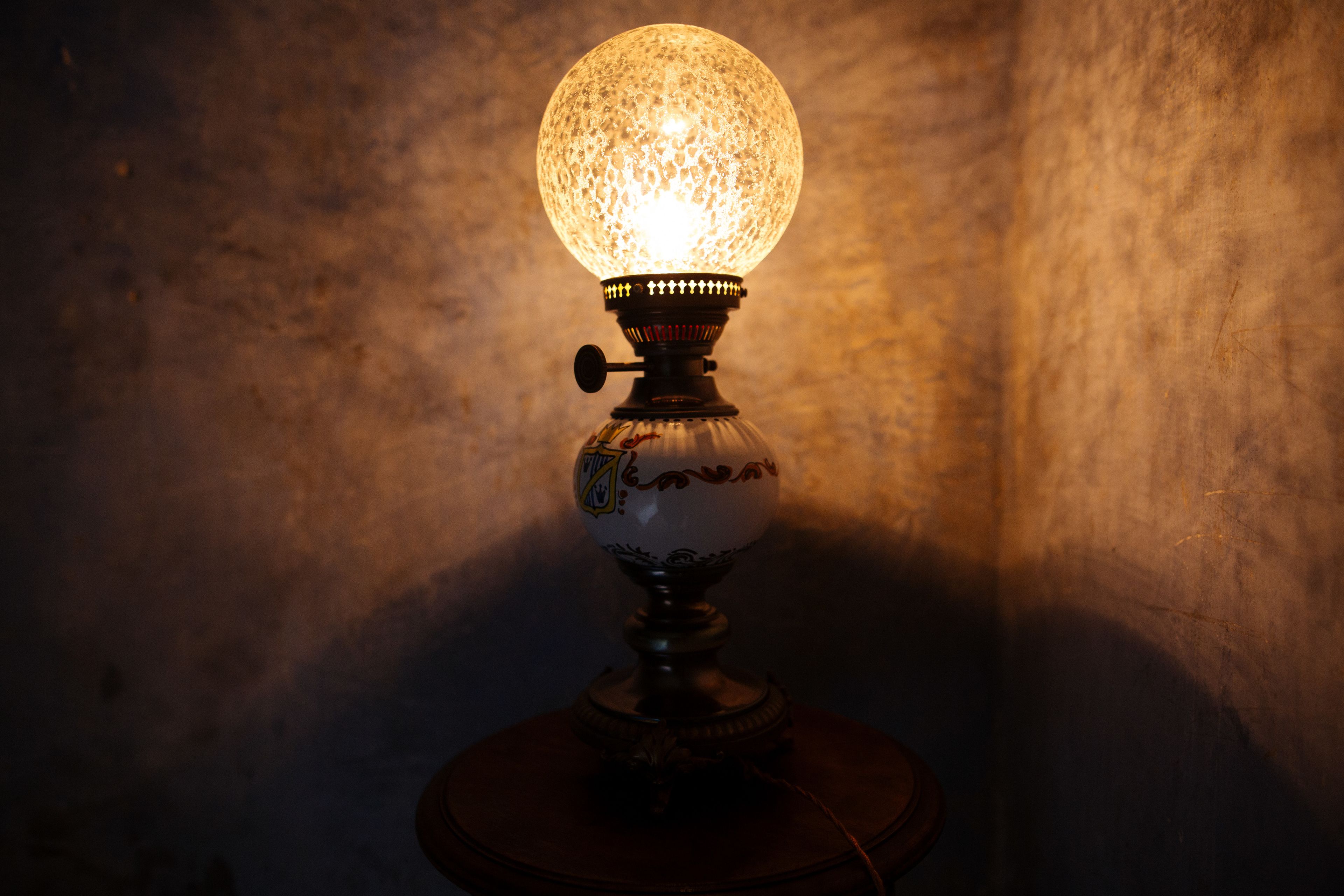 A vintage-style table lamp with a decorative glass shade and intricate base design.