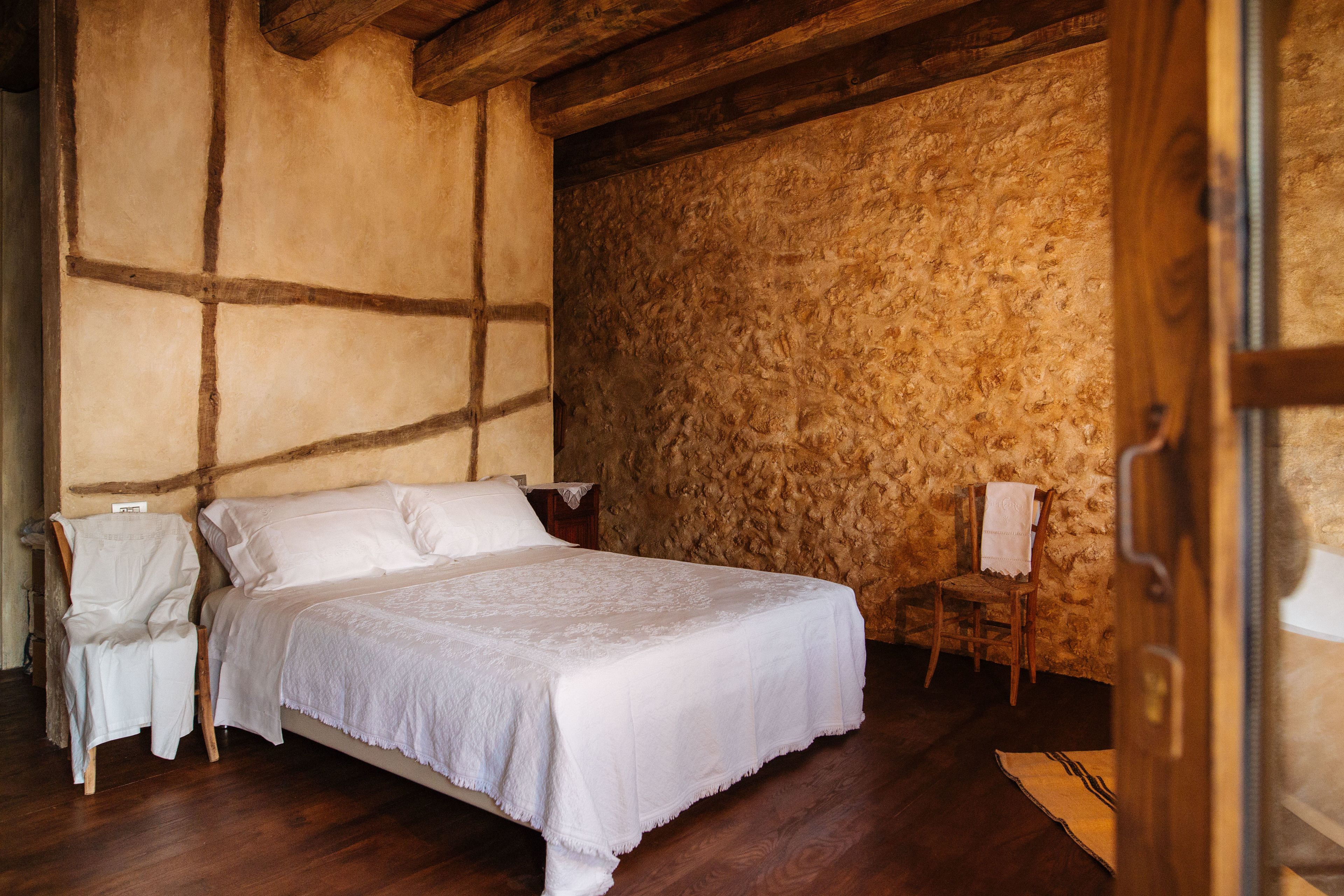 Un dormitorio con una cama de madera, una silla y una mesita.